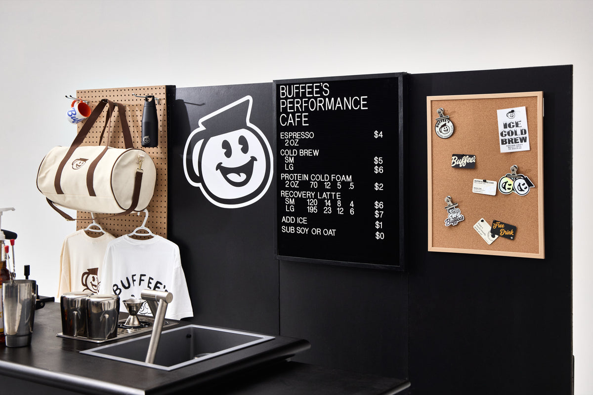 The cart's back wall with mascot sign, letterboard menu and merch