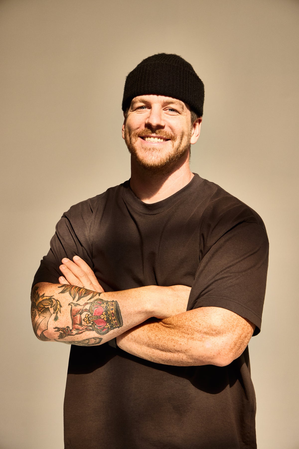 Will Robinson smiling with his arms crossed